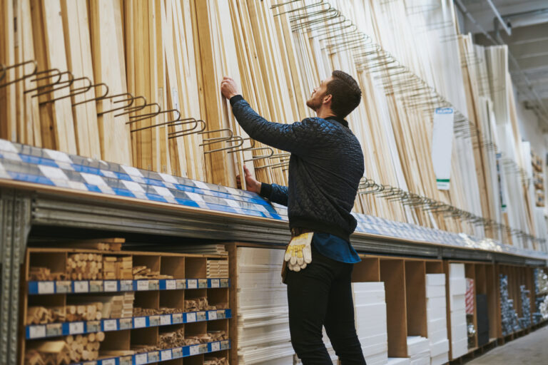 A hardware store person selecting a length of timber
